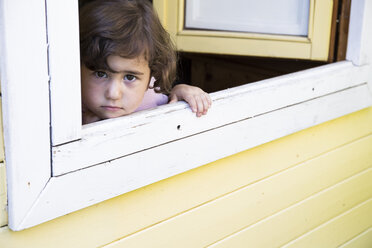 Portrait of little girl looking through open window - ABZF000975