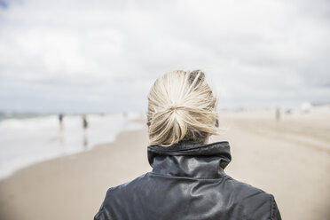 Rückenansicht einer Frau mit Lederjacke am Strand - CHPF000285