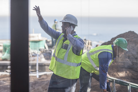 Männer mit Warnwesten auf einer Baustelle, lizenzfreies Stockfoto