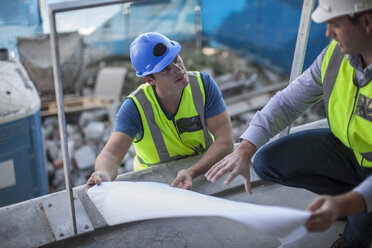 Two men on construction site discussing construction plan - ZEF009432