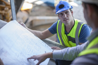 Two men on construction site discussing construction plan - ZEF009433