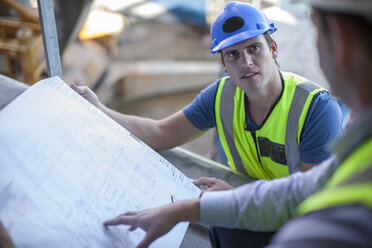 Zwei Männer auf einer Baustelle besprechen einen Bauplan - ZEF009433