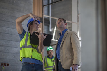 Two men discussing on construction site - ZEF009437