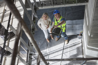 Bauarbeiter im Gespräch mit Frau auf der Baustelle - ZEF009446