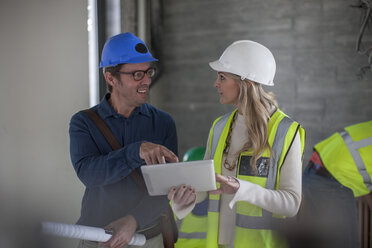 Man and woman on construction site with hard hats and tablet - ZEF009450