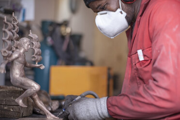 Mann bei der Arbeit an einer Bronzefigur - ZEF009495