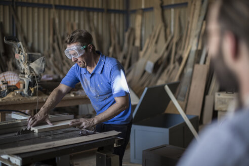 Carpenter working with saw in workshop - ZEF009517