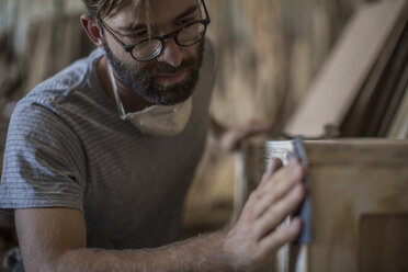 Carpenter sanding a wooden box - ZEF009522