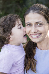 Porträt einer glücklichen Mutter mit kleiner Tochter, die sie küsst - ABZF000987