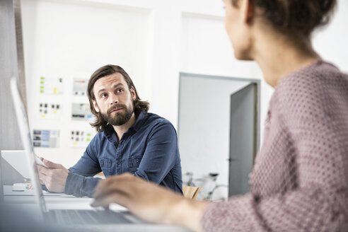 Zwei Kollegen im Büro stehen sich gegenüber - RBF004919