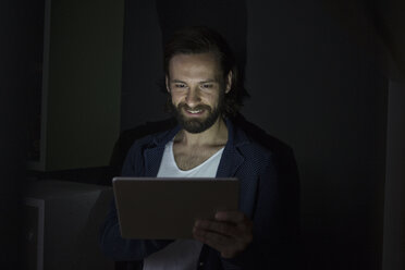 Man using digital tablet in the dark - RBF004927