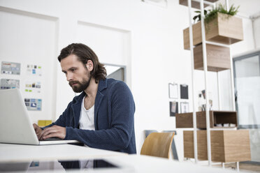 Man using laptop in office - RBF004931