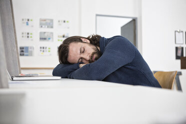 Man sleeping on desk in office - RBF004932
