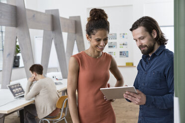 Zwei Kollegen arbeiten zusammen mit einem digitalen Tablet im Büro - RBF004967