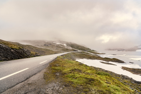Norwegen, Hedmark, Tufsindalen Tal, Landstraße und Wolken, lizenzfreies Stockfoto