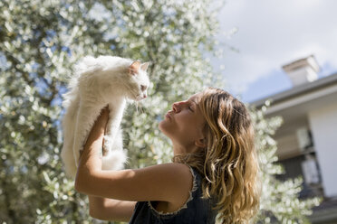 Frau mit ihrer Katze im Garten - MAUF000817