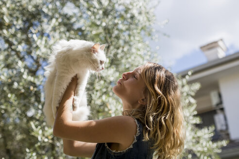 Frau mit ihrer Katze im Garten - MAUF000817