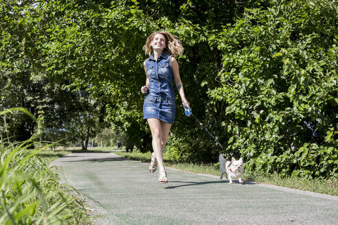 Glückliche Frau geht mit ihrem Chihuahua spazieren - MAUF000832