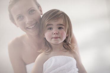 Lächelnde junge Frau und kleines Mädchen in ein Handtuch gewickelt - ZEF009606
