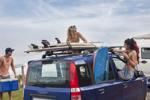 Freunde mit Surfbrettern auf dem Auto an der Küste - ZEF009615