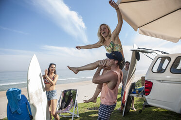 Man lifting up excited woman at the coast - ZEF009627