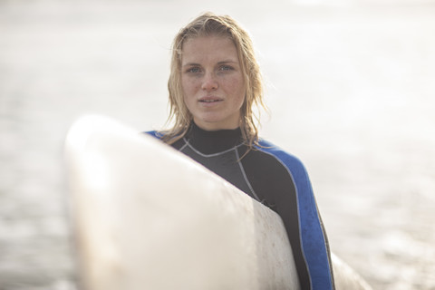 Porträt einer jungen Frau mit Surfbrett, lizenzfreies Stockfoto