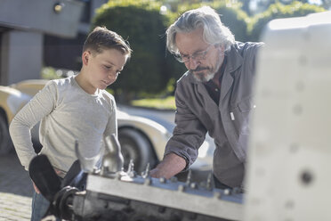 Ein älterer Mann erklärt einem Jungen den Mechanismus eines Autos - ZEF009652