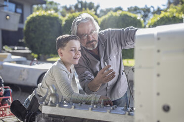 Ein älterer Mann erklärt einem Jungen den Mechanismus eines Autos - ZEF009653
