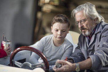 Ein älterer Mann erklärt einem Jungen ein Cabrio - ZEF009658