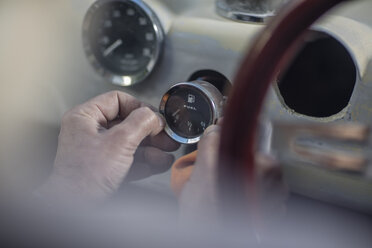 Senior man adjusting fuel gauge of a car - ZEF009663