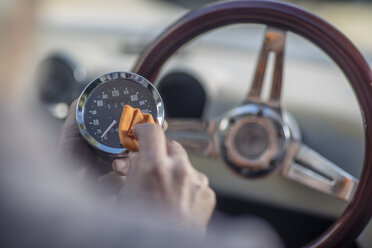 Älterer Mann poliert den Tachometer eines Autos - ZEF009664