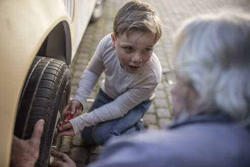 Älterer Mann und Junge wechseln Autoreifen - ZEF009671