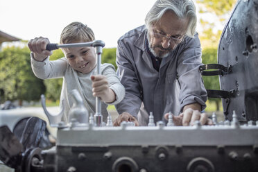 Älterer Mann und Junge arbeiten am Mechanismus eines Autos - ZEF009686