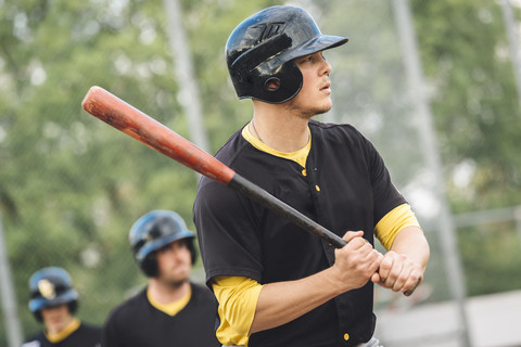 Baseballspieler hält Schläger, lizenzfreies Stockfoto