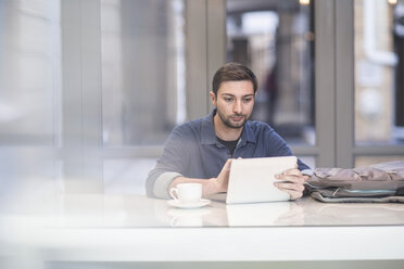 Mann benutzt digitales Tablet am Schreibtisch im Büro - ZEF009700