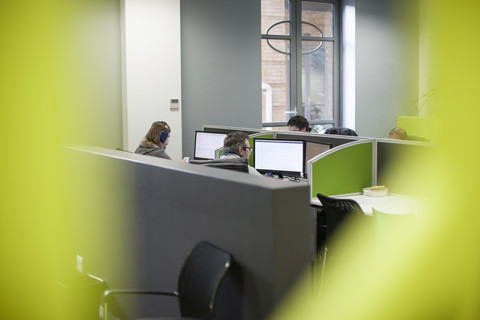 Mitarbeiter, die an Computern in Bürokabinen arbeiten, lizenzfreies Stockfoto