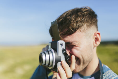 Junger Mann beim Fotografieren mit Polaroidkamera - BOYF000532