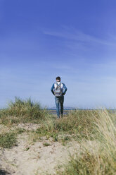 Back view of young man walking on a dune - BOYF000546