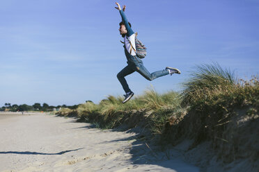 Junger Mann springt am Strand in die Luft - BOYF000548