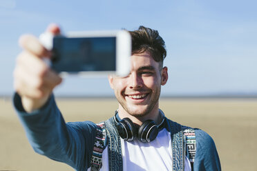 Young man taking selfie with smartphone on the beach - BOYF000557