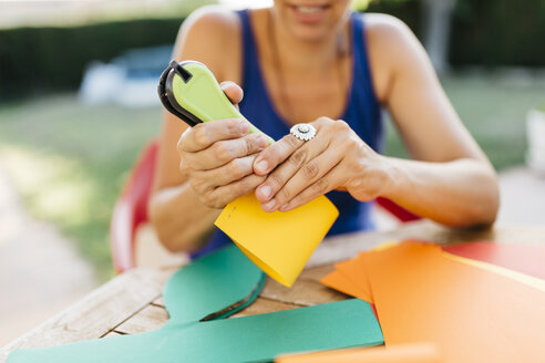 Woman doing handicrafts at garden table - JRFF000839