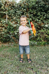 Junge hält selbstgebastelte Pappblume im Garten - JRFF000850
