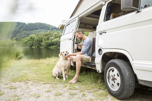 Mann mit Hund in einem Lieferwagen am Seeufer - FMKF002781