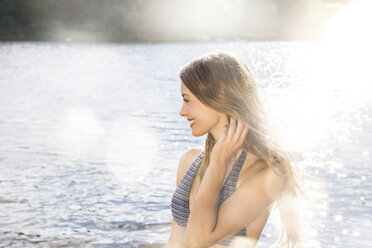Smiling young woman in a lake - FMKF002854