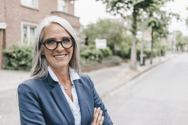 Portrait of smiling businesswoman wearing glasses - KNSF000305
