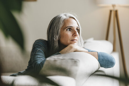 Pensive woman on the couch at home - KNSF000331