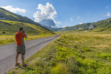 Italy, Abruzzo, Gran Sasso e Monti della Laga National Park, Photographer shooting plateau Campo Imperatore and Corno Grande mountain - LOMF000349