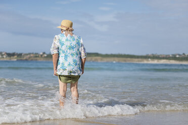 Rückenansicht einer älteren Frau am Meeresufer - RAEF001431