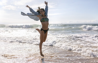 Spain, Asturias, beautiful young woman jumping on the beach - MGOF002202