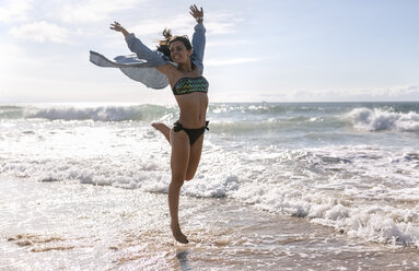 Spanien, Asturien, schöne junge Frau springt am Strand - MGOF002202